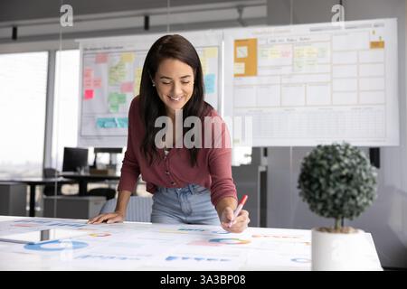 Positive junge lateinische Projektmanagerin, die eine Marketingstrategie entwickelt Stockfoto