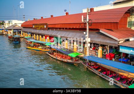 Amphawa, Thailand - 15. Dezember 2019: Geschäftiger schwimmender Markt in Amphawa bei Sonnenuntergang mit Booten, die frische Meeresfrüchte und Souvenirs in Thailand verkaufen. Stockfoto