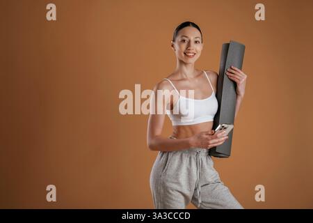 Bereit für die Übung, stehend. Die schöne Fitness-Frau ist im Studio. Stockfoto