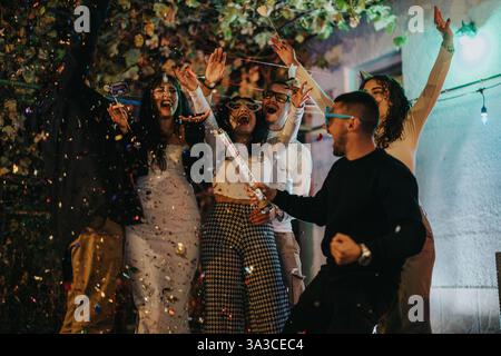 Multikulturelle Freunde feiern eine lustige Geburtstagsparty mit Konfetti und Lachen Stockfoto