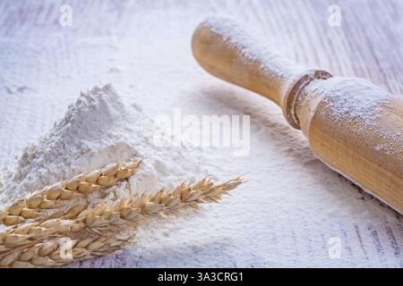Holzstift und Mehl mit Ähren von Weizen auf Vintage-Brett Stockfoto