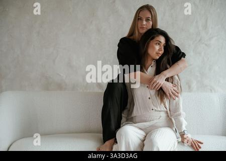 Freunde nehmen sich an. Zwei glückliche junge Frauen sind drinnen. Stockfoto