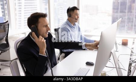 Fokussierter, seriöser, hispanischer Projektmanager, der mit Geschäftskollegen spricht Stockfoto