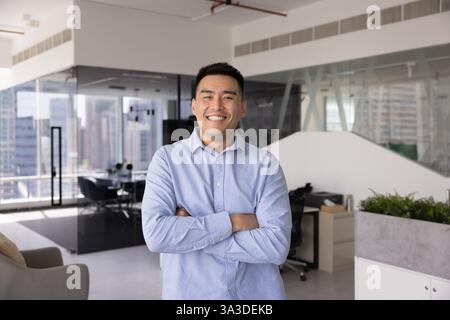 Glücklicher, zuversichtlicher asiatischer Executive-Mann, der für ein professionelles Firmenporträt posiert Stockfoto