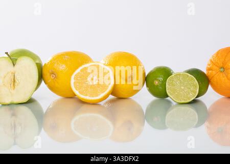 Eine bunte Auswahl an frischen und köstlichen Früchten auf einer reflektierenden Oberfläche Stockfoto