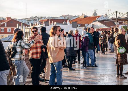 Lissabon, Portugal - 2. Januar 2025: Menschen im Miradouro de Santa Catarina genießen den Sonnenuntergang über Lissabon Stockfoto