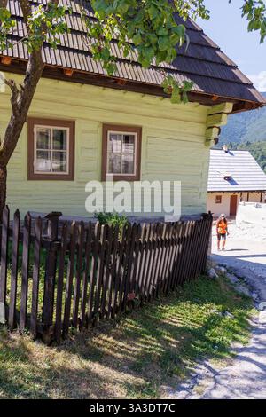 Person, die am Haus im Dorf Vlkolinec, Slowakei, vorbeiläuft Stockfoto