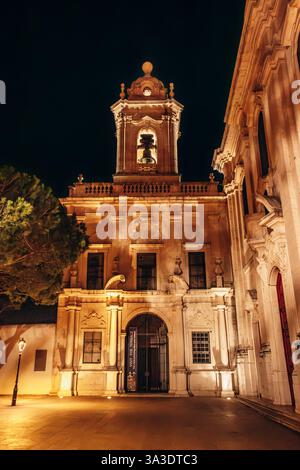 Ein Nachtfoto der Kirche unserer Lieben Frau von Gnade in Lissabon mit ihrem beleuchteten Glockenturm und kunstvoller Architektur. Stockfoto