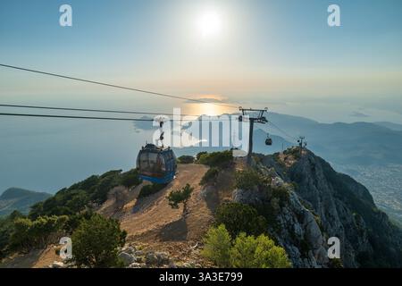 Babadag Bergwelt bei Sonnenuntergang mit Seilbahn mit Blick auf den Strand Oludeniz in Fethiye, Türkei Stockfoto