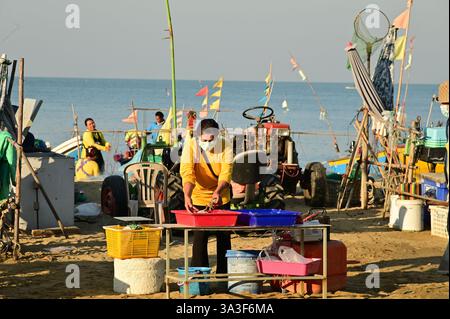 Einheimische Fischer verkaufen ihren gefangenen Fisch am Morgen an Touristen, nachdem sie vom Nachtfischen am Na Jomtien Beach, Pattaya, zurückgekehrt sind. Stockfoto
