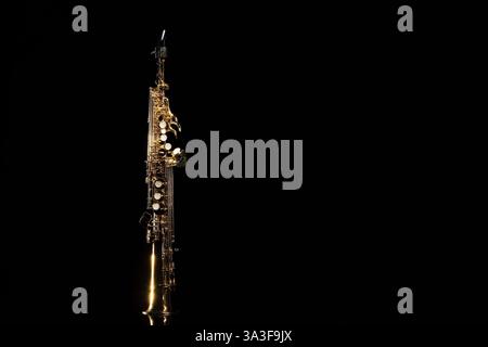 Jazz. Ein Saxophon auf Spiegelfläche vor schwarzem Hintergrund, Platz für Text Stockfoto