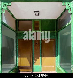 Ein historischer Ladeneingang in Chicagos Chinatown mit komplexen grünen architektonischen Details und großen Schaufenstern. Stockfoto