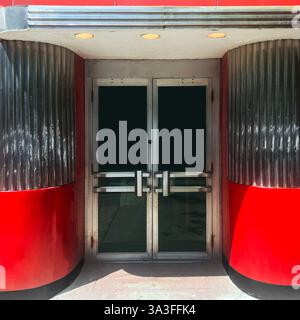 Ein stromlinienförmiger Moderne-Eingang in Chicago mit auffälligen Rot- und Chromakzenten mit eleganten Metallic-Details und Retro-Ästhetik. Stockfoto