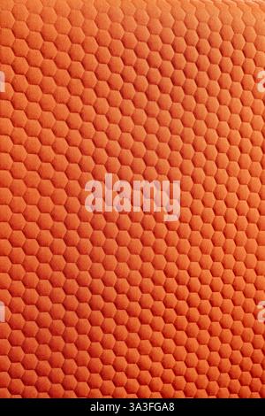 Leuchtend orangefarbene Textur mit markantem sechseckigem Muster, perfekt für Hintergrundtextilien und Designprojekte Stockfoto
