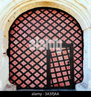 Die mittelalterliche Tür in Krakaus Altstadt, Polen, ist mit einem schwarzen Gartentor von dimond und roten Blumenmustern in einem Stein versehen Stockfoto
