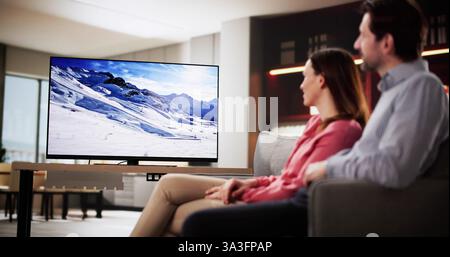 Ein Paar genießt einen Filmabend auf dem Wohnzimmer Sofa. Stockfoto