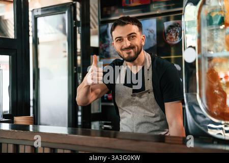 Daumen hoch. Der Mann serviert köstliches Street Food. Stockfoto