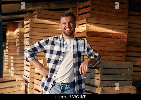 Man Farmer ist drinnen mit Holzkisten im Lager. Stockfoto