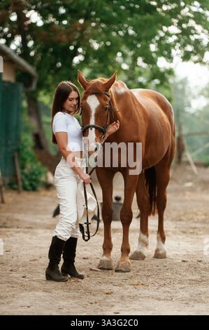 Auf dem Bauernhof. Die junge schöne Frau ist draußen mit einem Pferd. Stockfoto