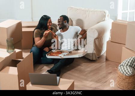 Feiern, Pizza essen. Afroamerikaner ziehen in ein neues Haus. Stockfoto