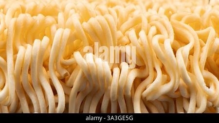Textur des trockenen Instant-Nudeln-Hintergrunds. Rohe getrocknete Instant-Ramen-Nudeln blockieren Stockfoto
