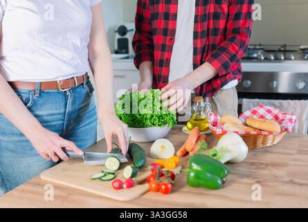 Junge Paare, die eine Mahlzeit zubereiten Gemüse in der Küche zu Hause hacken, gesunde Lebensweise. Stockfoto