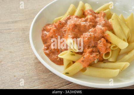 Penne Pasta backen, Lachsscheiben in süß-saurer Sauce auf dem Teller Stockfoto