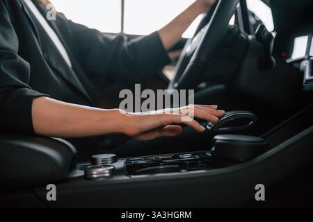 Nahaufnahme von Frauenhänden, die ein neues Auto fahren. Stockfoto