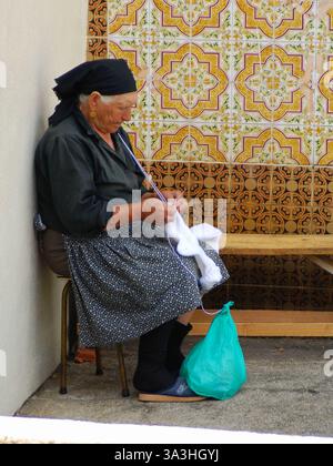Sehr alte einsame Dame strickt Wollsocken Stockfoto