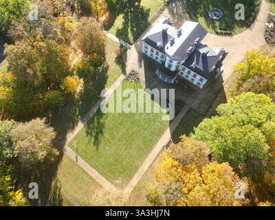 Blick aus der Vogelperspektive auf ein Herrenhaus, umgeben von Bäumen im Herbst Stockfoto