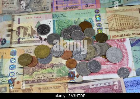 Münzen aus verschiedenen Ländern und Europa auf verschiedenen Banknoten aus verschiedenen Ländern wie irakische Dinar, libyscher Dinar, sudanesische Pfund, indische Rupie Stockfoto