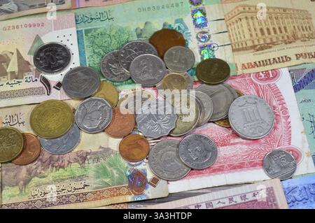 Münzen aus verschiedenen Ländern und Europa auf verschiedenen Banknoten aus verschiedenen Ländern wie irakische Dinar, libyscher Dinar, sudanesische Pfund, indische Rupie Stockfoto