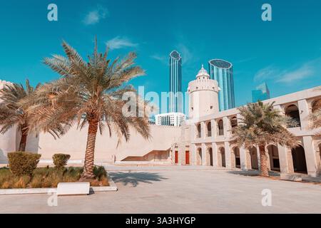 16. Januar 2025, Abu Dhabi, VAE: Historisches Fort Qasr al Hosn, umgeben von Palmen und modernen Gebäuden Stockfoto