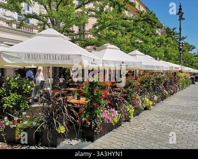 Essen im Freien im Sommer im Restaurant Amalia Steak and Fish auf dem Hauptmarkt in Krakau Polen namens Rynek Główny. Stockfoto