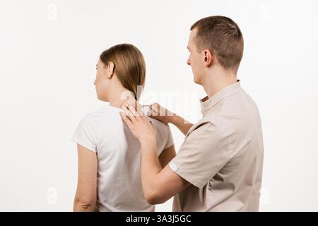 Orthopäde bei der Untersuchung von Hals und Kopf der Frau. Die manuelle Korrektur des Kamms und der Halsregion. Rehabilitationstherapie auf weißem Hintergrund. Manuell den Stockfoto