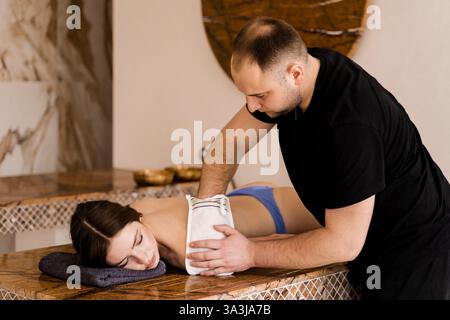 Türkische Schaummassage und Peeling mit Kese-Handschuh. Entspannung im Spa-Center. Masseur macht Massage Stockfoto
