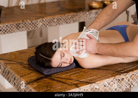 Entspannung im Wellnesscenter. Der Masseur macht eine Massage. Türkischer Schaum Massage und Peeling mit Kese Handschuh Stockfoto