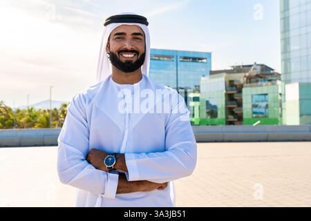 Traditioneller arabischer Mann, der im Freien emirat Kandura trägt - hübsches männliches Geschäftsmann-Porträt aus dem Nahen Osten in der Stadt Stockfoto