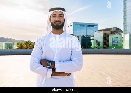 Traditioneller arabischer Mann, der im Freien emirat Kandura trägt - hübsches männliches Geschäftsmann-Porträt aus dem Nahen Osten in der Stadt Stockfoto
