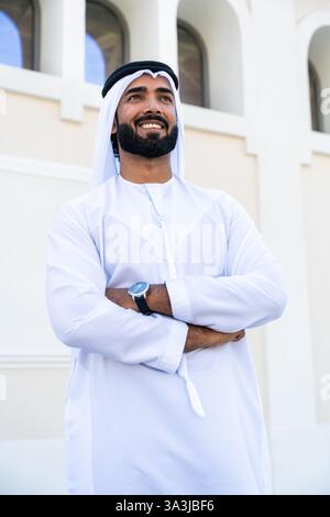 Traditioneller arabischer Mann, der im Freien emirat Kandura trägt - hübsches männliches Geschäftsmann-Porträt aus dem Nahen Osten in der Stadt Stockfoto