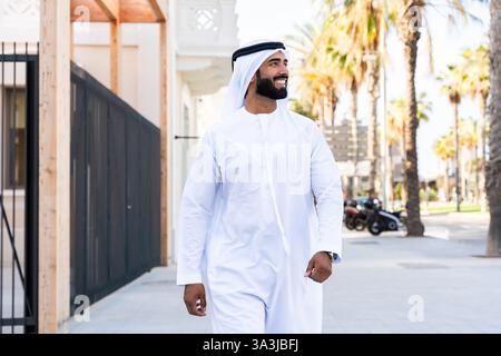 Traditioneller arabischer Mann, der im Freien emirat Kandura trägt - hübsches männliches Geschäftsmann-Porträt aus dem Nahen Osten in der Stadt Stockfoto