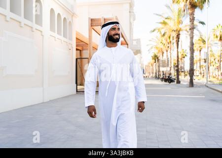 Traditioneller arabischer Mann, der im Freien emirat Kandura trägt - hübsches männliches Geschäftsmann-Porträt aus dem Nahen Osten in der Stadt Stockfoto