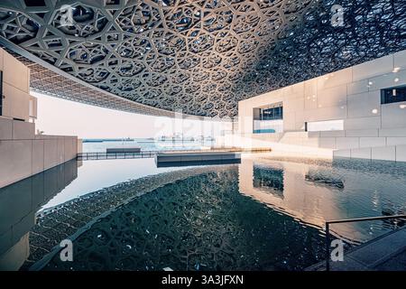 17. Januar 2025, Abu Dhabi, VAE: Moderne Architektur des Louvre Museums in Abu Dhabi, reflektiert auf der Wasseroberfläche unter der ikonischen Kuppel Stockfoto