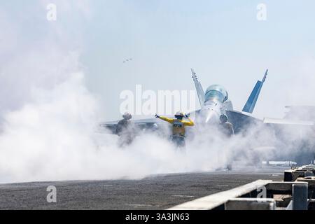 USS Harry S. Truman, International Waters. 13. März 2025. Ein US-Navy-Matrosen steuern ein F/A-18F Super Hornet Jagdflugzeug, das an die Red Rippers of Strike Fighter Squadron 11 angehängt ist, zum Katapult, um vom Flugdeck des Flugzeugträgers USS Harry S. Truman zu starten, der am 13. März 2025 im Roten Meer operiert. Kredit: MC2 Logan McGuire/U. S Navy Photo/Alamy Live News Stockfoto