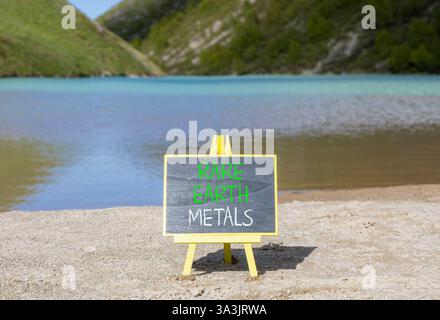 Symbol für Seltenerdmetalle. Konzeptworte seltene Metalle auf wunderschöner Tafel. Wunderschöner Bergsee im Hintergrund. Gewerbe- und Seltenerdmetalle Stockfoto