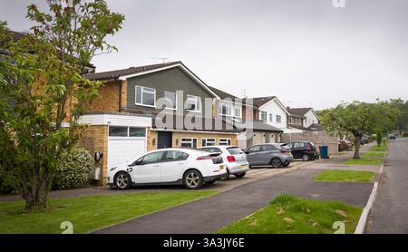 London, Großbritannien - 18. Mai 2024. Reihe von Vorort-Einfamilienhäusern mit Autos, die auf der Einfahrt geparkt sind. Pinner, London, Großbritannien Stockfoto