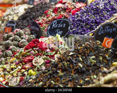 Verschiedene getrocknete Blumen, Kräuter und Tees in lebhaften Farben mit handgeschriebenen Etiketten an einem Marktstand Stockfoto