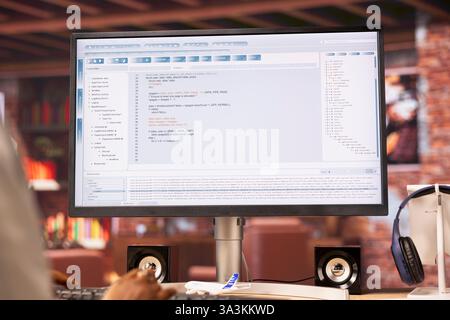 Kodierer am Arbeitsplatz Programmierung auf dem Computer, Schreiben von Codezeilen, Verwenden von Entwicklungstools. Frau im Heimbüro, die versucht, das Debugging der Software vor Ablauf der Frist abzuschließen, Nahaufnahme auf dem PC-Monitor Stockfoto