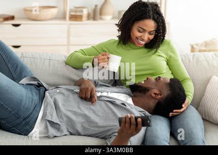 Ein Paar genießt einen gemütlichen Moment zusammen auf einem Sofa in einem hellen Wohnzimmer Stockfoto