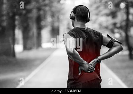 Rückansicht des schwarzen Mannes in Sportkleidung berühren verletzten Rücken Stockfoto